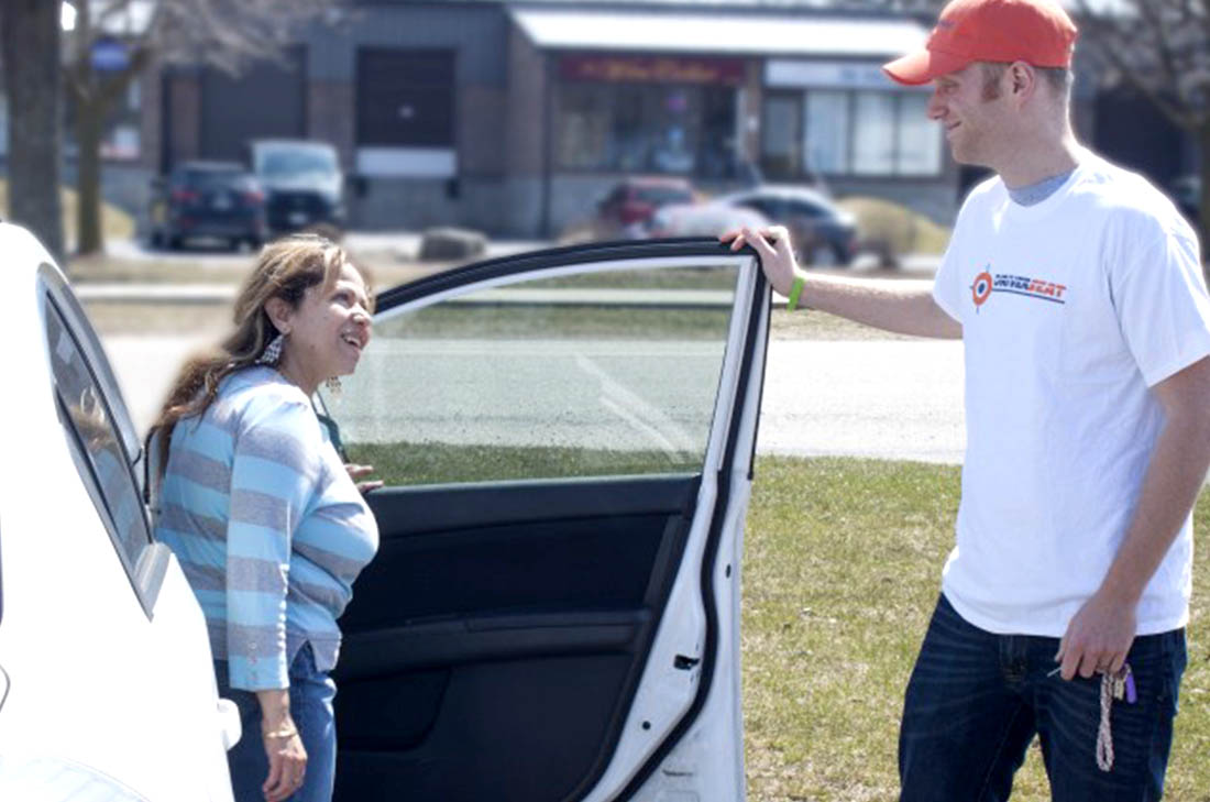 Man opening car door for female passenger