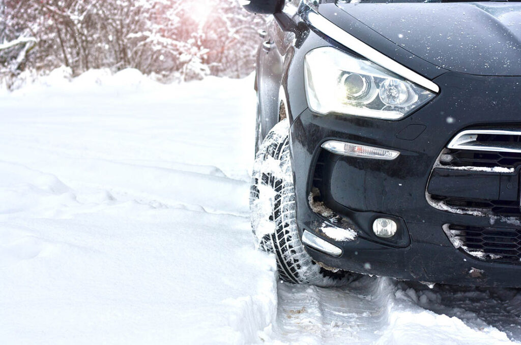 closeup of car and winter tires in snow