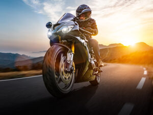 closeup of motorcycle on a highway with setting sun behind