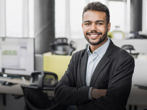 Professional consultant with arms crossed smiling at camera in an office environment