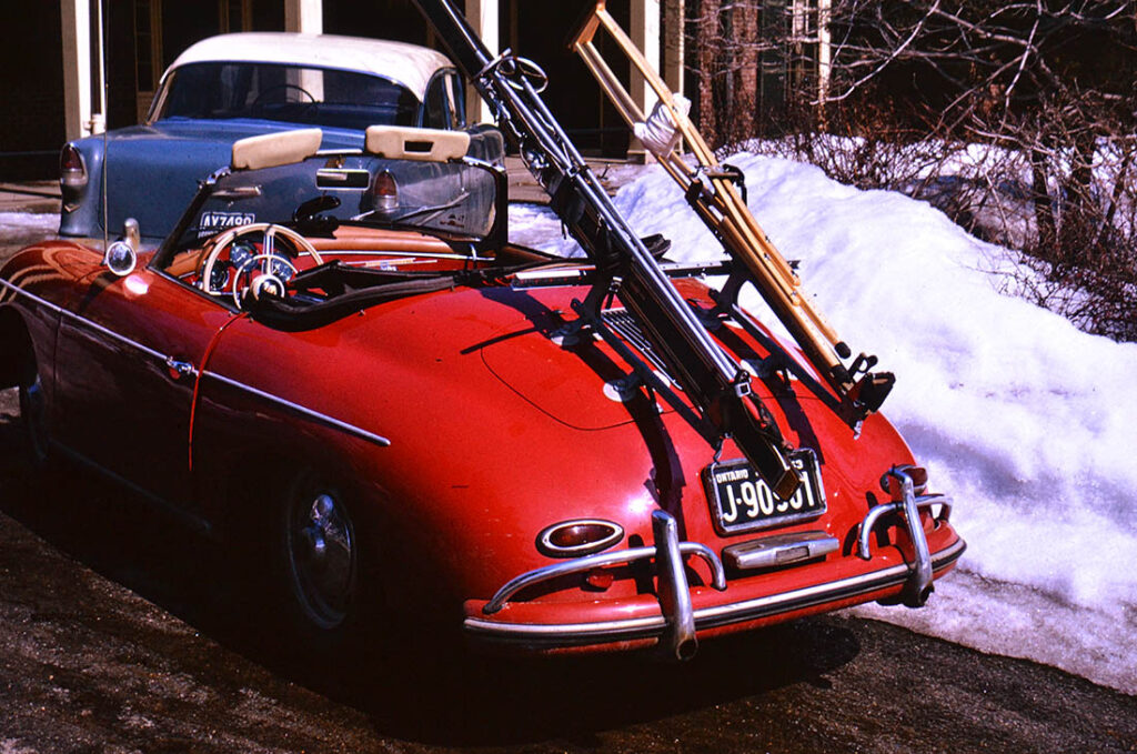 red 1959 porsche with skiis and crutches on the back