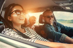 laughing family in a car with sunset behind them