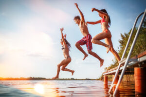 3 friends jumping in a lake off the dock