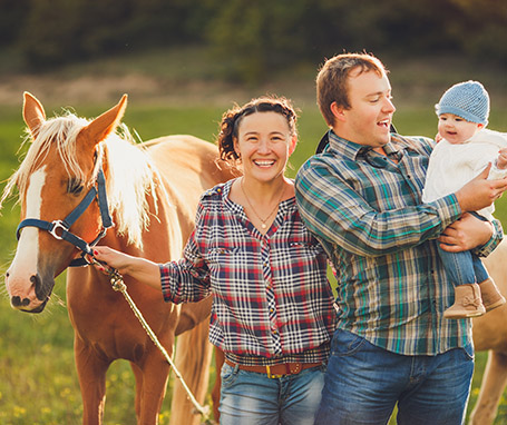 FAmily standing next to horse in a meadow