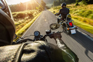 two motorcycle riders driving down country road