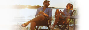 Couple sitting on the dock and sharing a joke