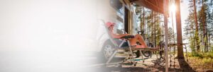 Woman relaxing in a lawn chair at a campsite beside her RV