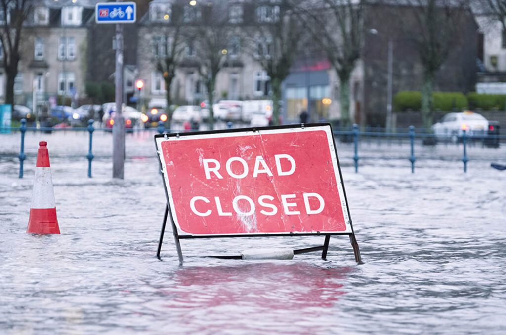 road closed sign in the middle of a flooded street