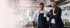 Restaurant owner and his chef standing in the kitchen