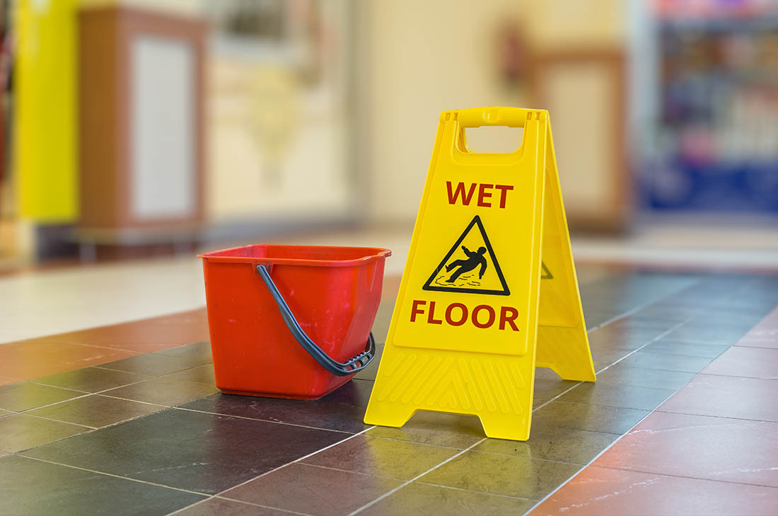 wet floor sign next to a red bucket