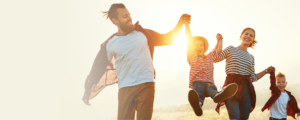 Happy family running together through a wheat field