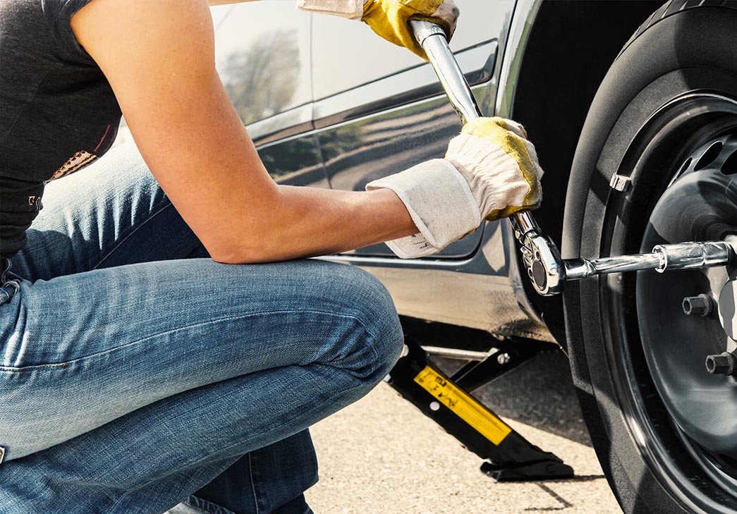 Woman changing a flat tire