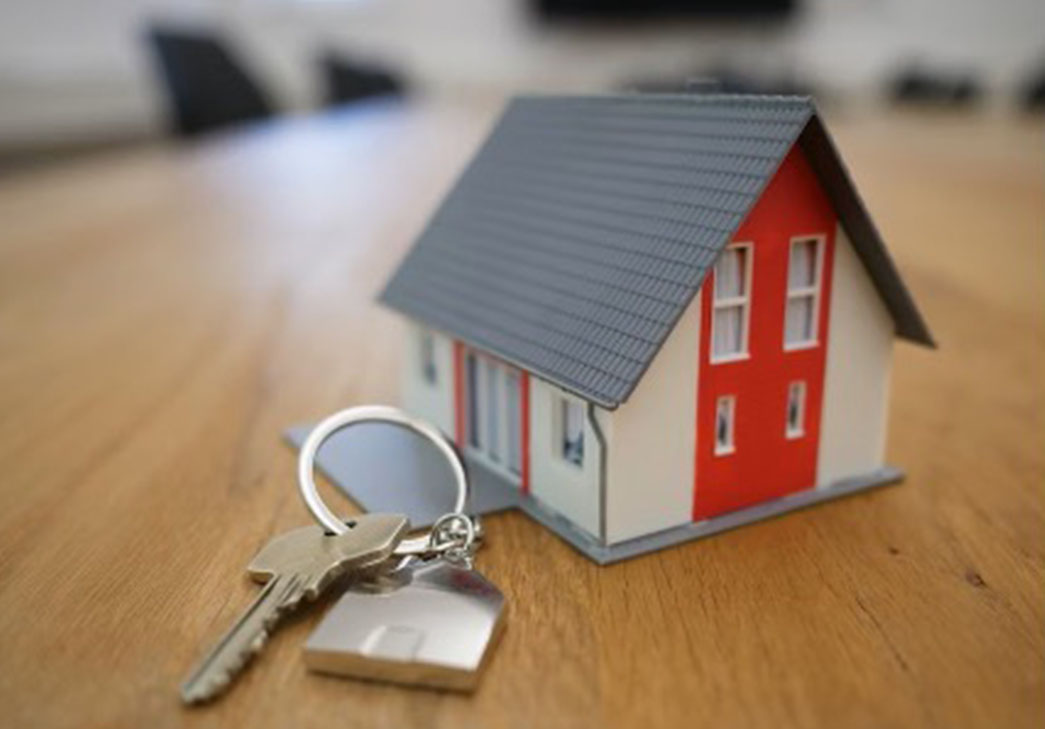 closeup of model home on a table with house keys in frontkeys on a