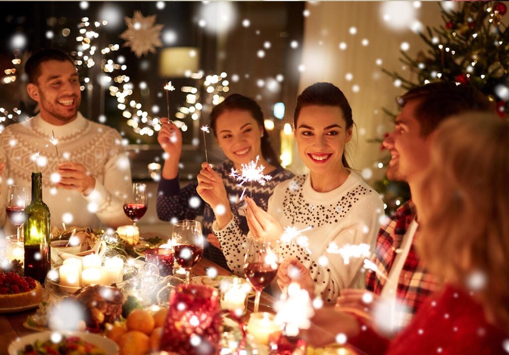 Happy family and friends with sparklers celebrating Christmas at home