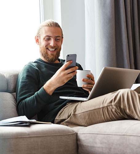 man relaxing on a sofa with his phone