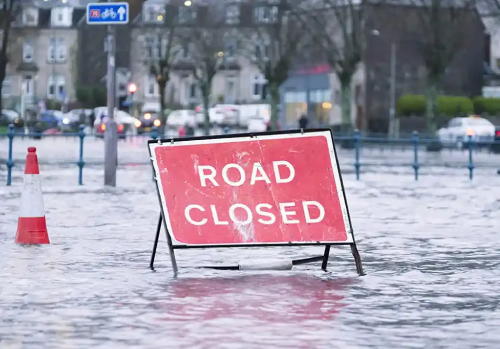road closed sign in the middle of a flooded street
