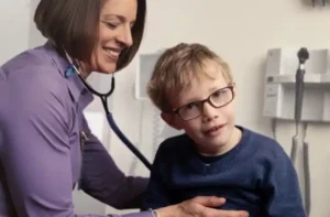 Nurse listening to young patient's heart