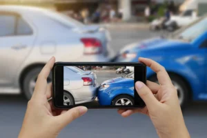 Close up hand holding smartphone and taking photo of car accident