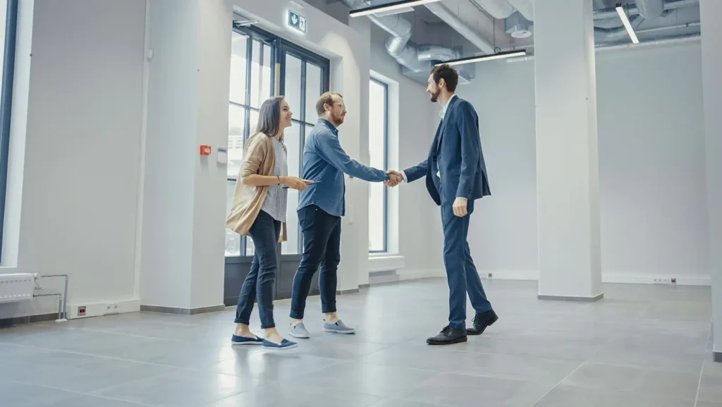 Entrepreneurs Meet their real estate agent in empty office space