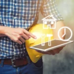 Engineer holding helmet and using tablet checking for project Construction.