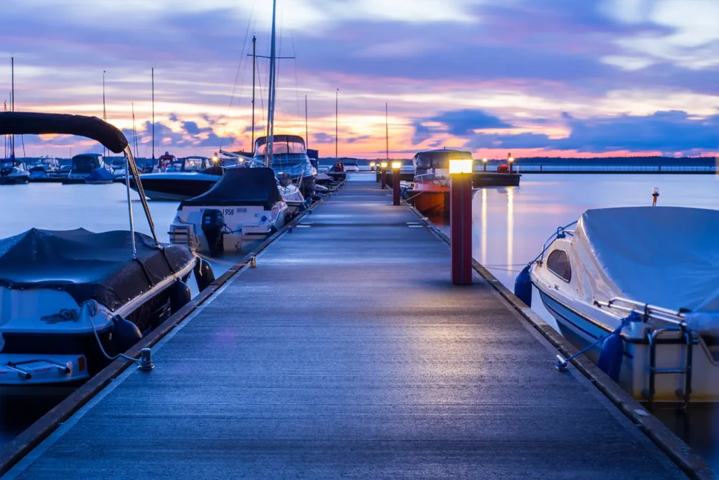 Boats parked at a marina at sunset