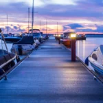 Boats parked at a marina at sunset
