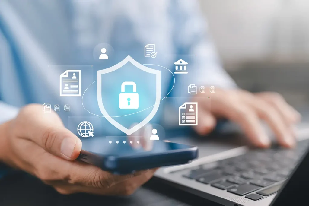 Businessman using smartphone and laptop with shield and padlock icons.