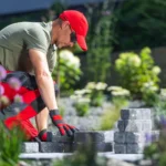 Landscaper installing paving stones in a garden